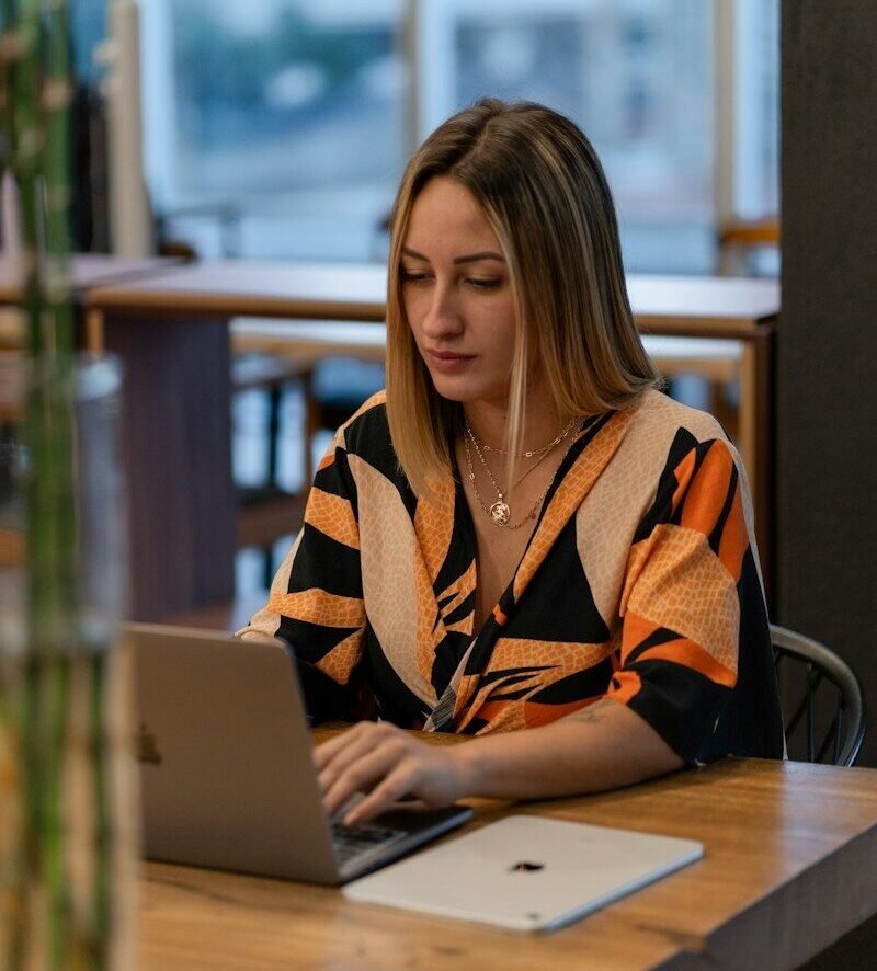 A woman works on her laptop in a cafe